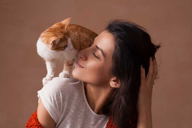 A cat on a woman's shoulder